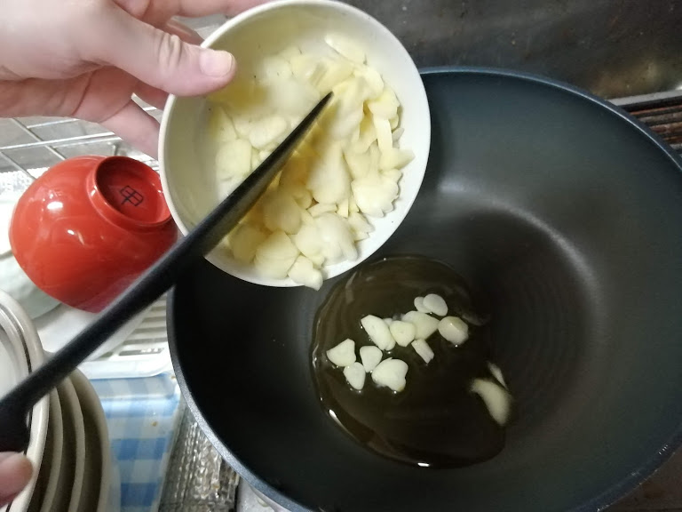 刻んだにんにくをフライパンで炒める